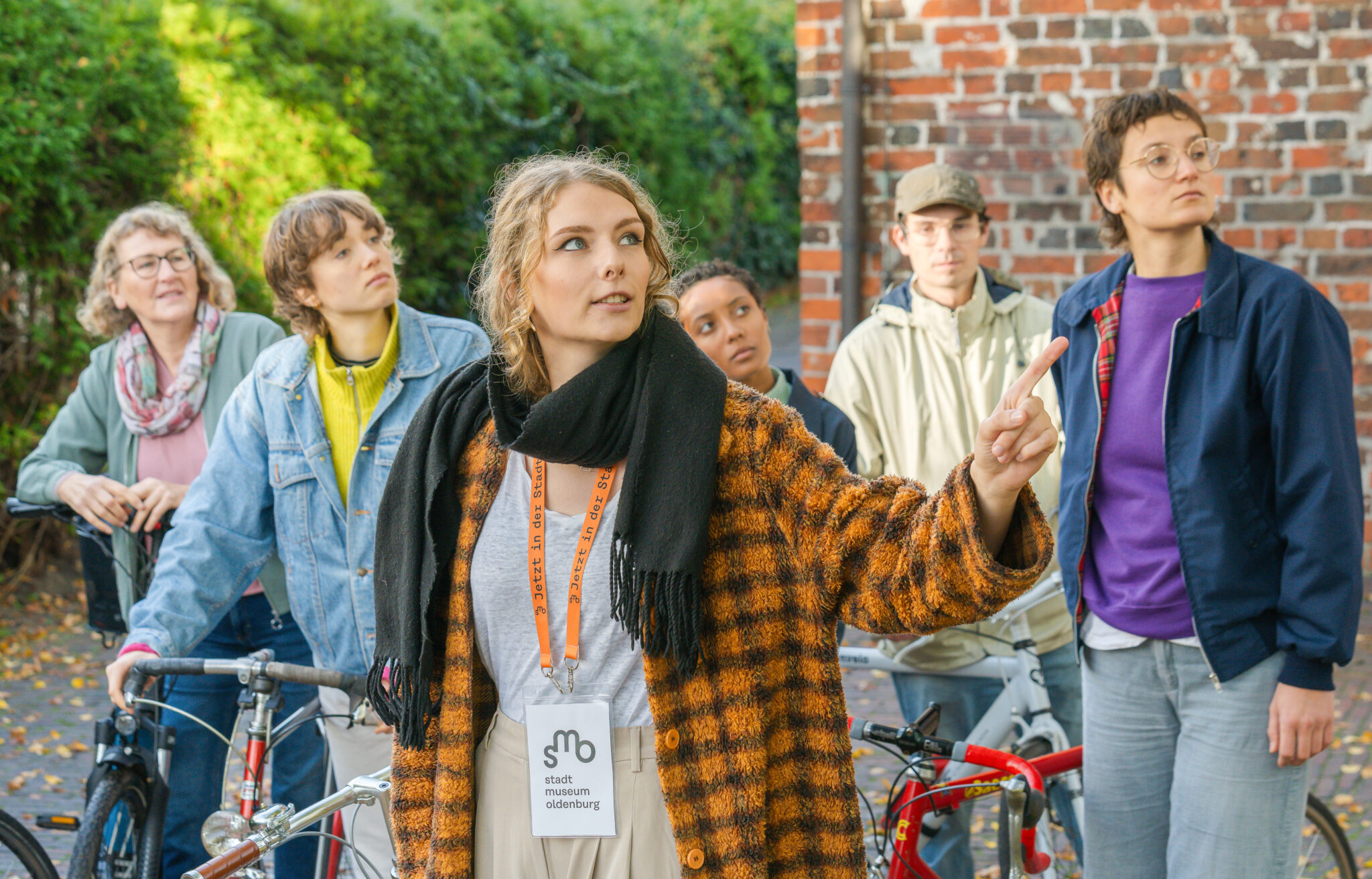 Eine Exkursions-Gruppe steht vor der St. Gertruden Kirche und schaut sich diese von Außen interessiert an, © Studio 3×3 Eine Exkursions-Gruppe steht vor der St. Gertruden Kirche und schaut sich diese von Außen interessiert an, © Studio 3x3