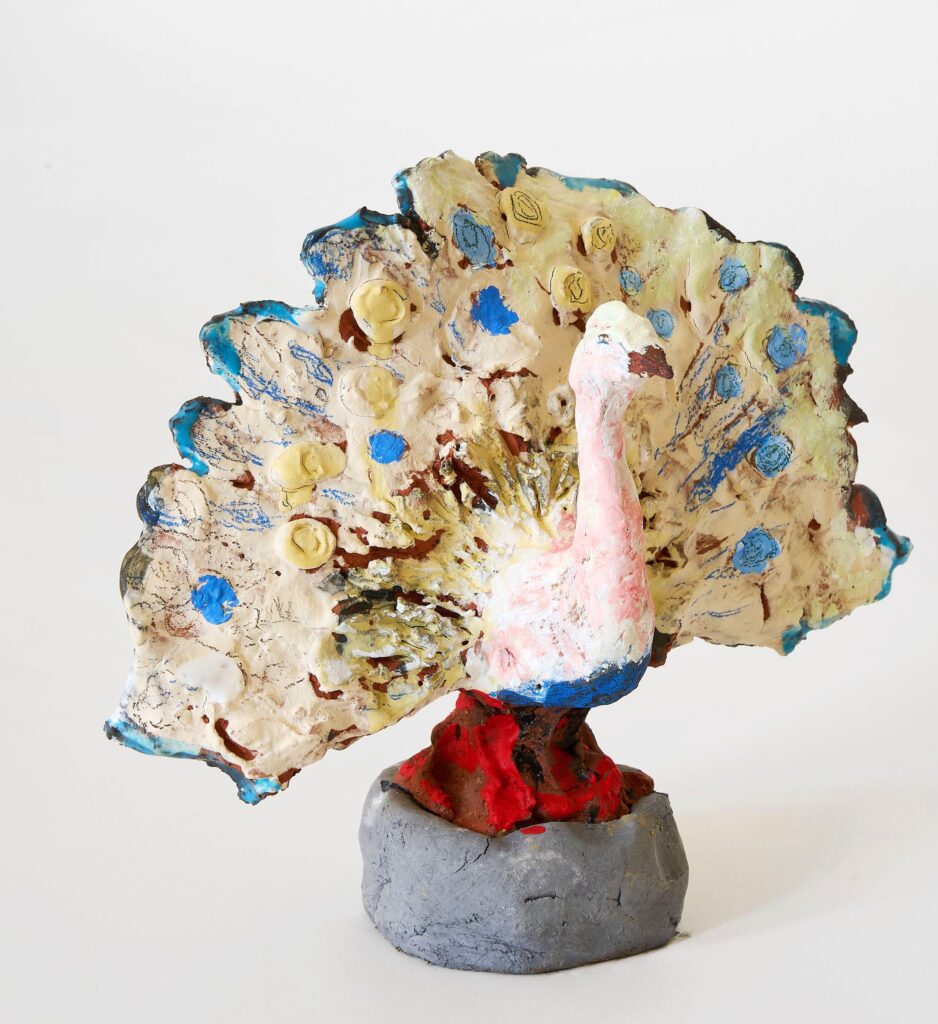 Carlo Leopold Broschewitz, Pfau, Keramik, Glasur, Acrylfarbe, 2025, © Carlo Leopold Broschewitz Keramikskulptur eines Pfau mit ausgebreitetem Rad, bemalt mit Acrylfarben, auf grauem Sockel, © Carlo Leopold Broschewitz