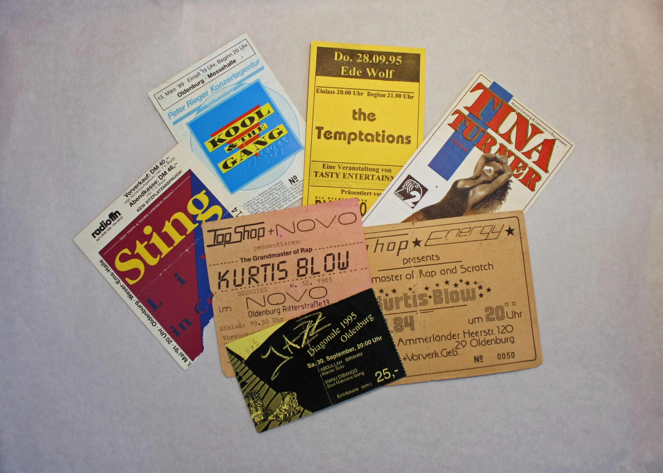 Mehrere Eintrittskarten für Konzerte in Oldenburg auf einer Unterlage, darunter Sting, the Temptations und Tina Turner, © Stadtmuseum Oldenburg