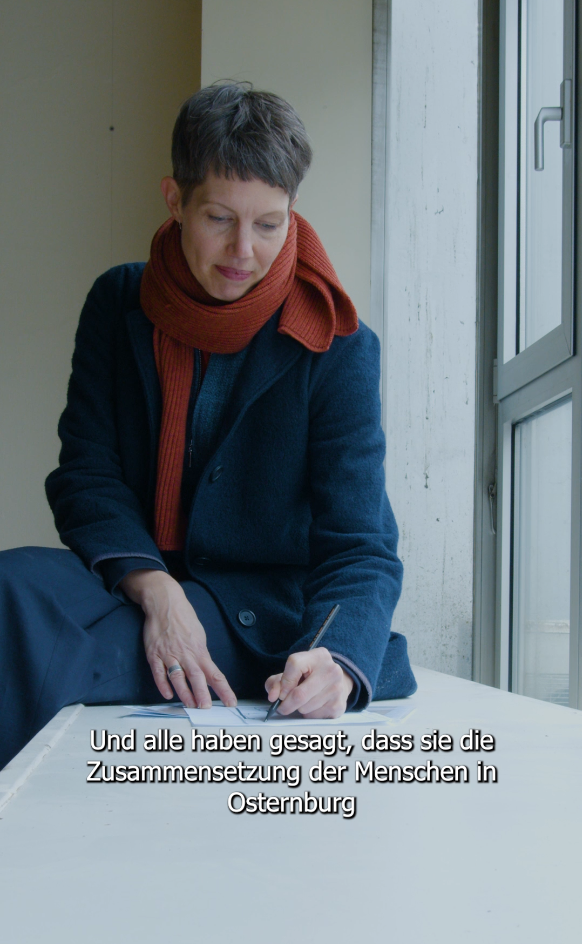 Sandrine Teuber sitzt auf einer Fensterbank und macht Notizen, © Stadtmuseum Oldenburg