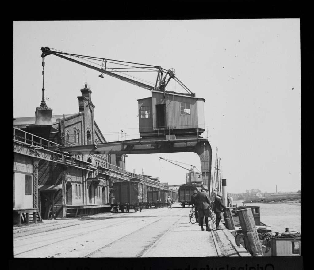 Von der Hafenstraße reicht der Blick bis zur Eisenbahnbrücke, die bis zu ihrer Zerstörung am Ende des Zweiten Weltkriegs eine Drehbrücke gewesen ist (1920er Jahre), © Stadtmuseum Oldenburg