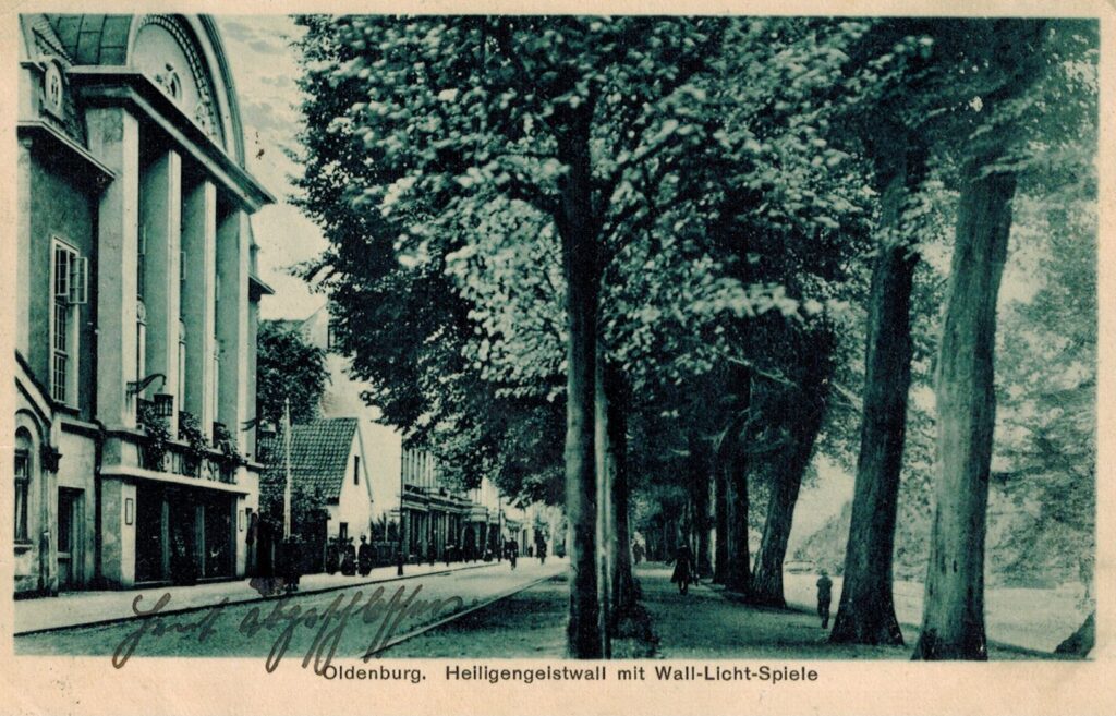 Abb. 1 PK12113 Grußkarte Heiligengeistwall Wallkino 1928 Heiligengeistwall in Oldenburg mit großen Bäumen und Gebäuden, darunter das Wall-Licht-Spiele Kino, 1928, Eine Postkarte aus dem Jahr 1928 zeigt die Wall Licht, © Stadtmuseum
