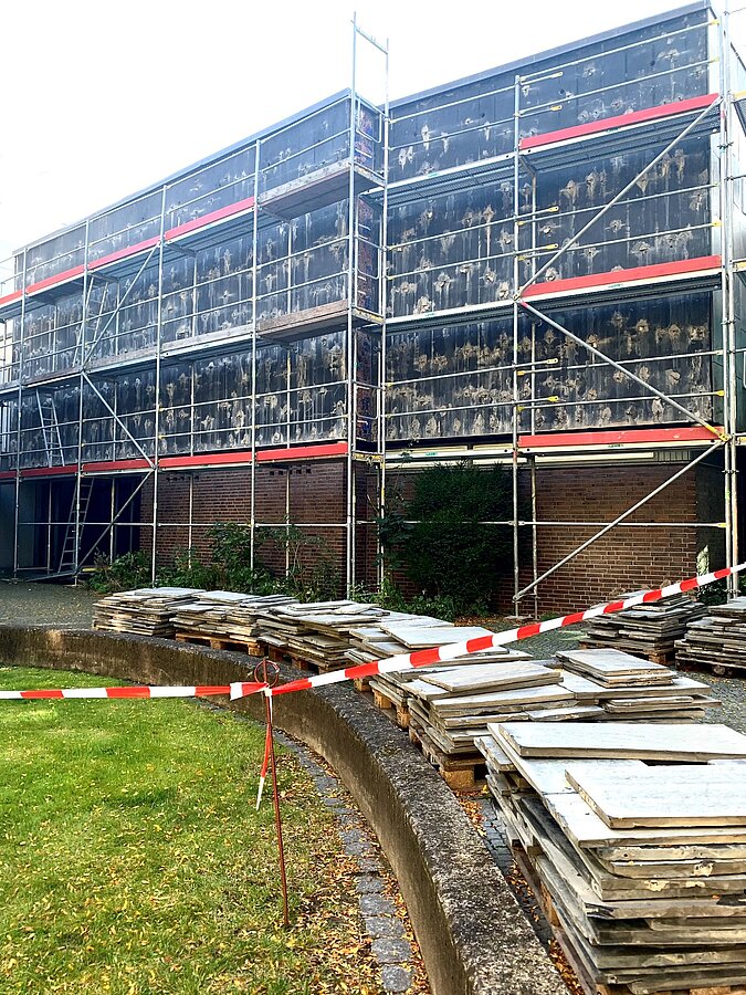 Abgenommene Schieferplatten liegen vor der Neuen Galerie, die mit einem Baugerüst umschlossen ist, © Stadtmuseum Oldenburg