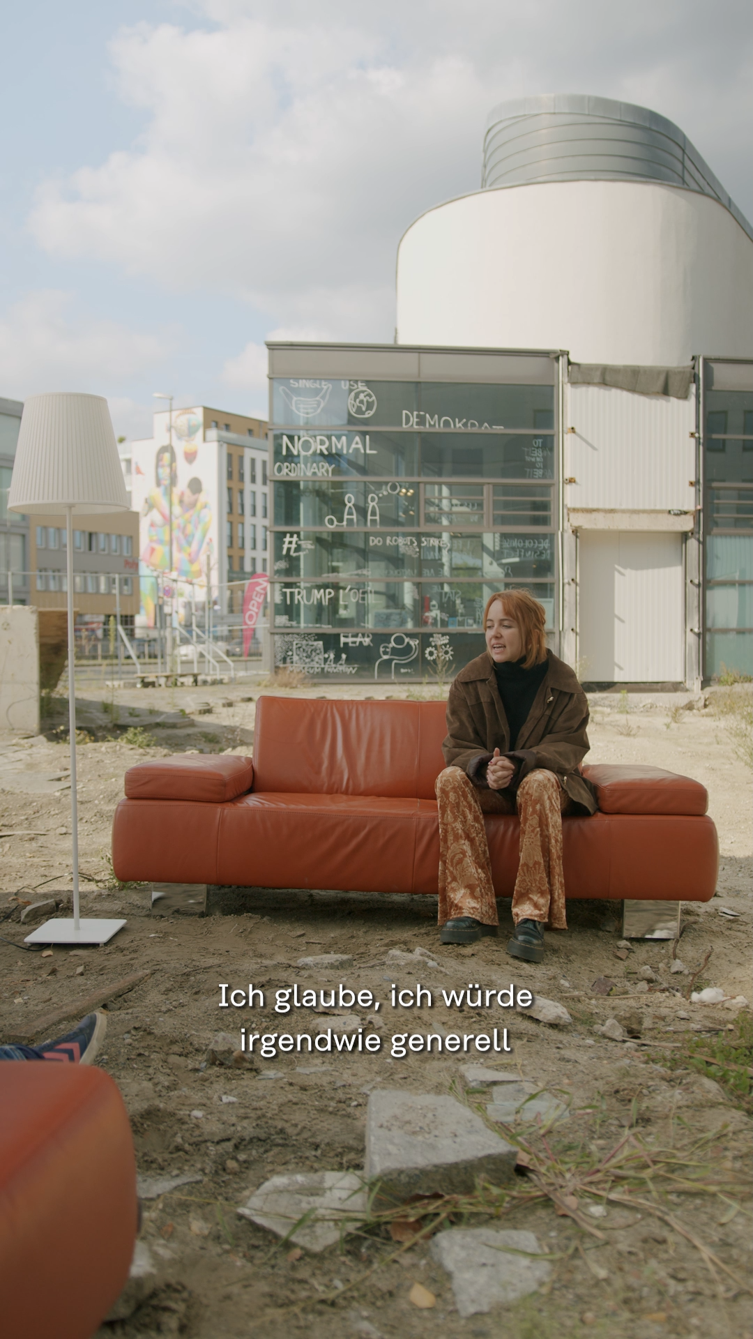 Junge Person sitzt auf rot-orangenem Sofa auf der Baustelle des alten Stadtmuseums, im Hintergrund das Horst-Janssen-Museum, © Stadtmuseum Oldenburg