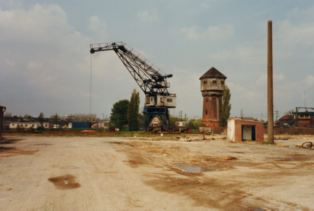 Brachfläche mit Sand, dahinter ein alter Wasserturm und ein Hafenkran, © Stadtmuseum Oldenburg/Bürger- und Gartenbauverein Osternburg