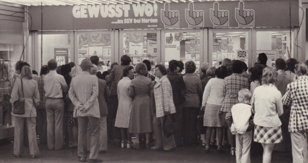 Menschen stehen vor einem Kaufhauseingang und warten, © Stadtmuseum Oldenburg/Günter Nordhausen