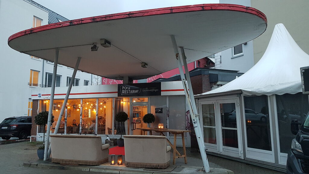 Pop Up Restaurant der Geschmacksträger in der ehemaligen Tankstelle mit Sofas unter dem Vordach, 2020, © Katharina Semling