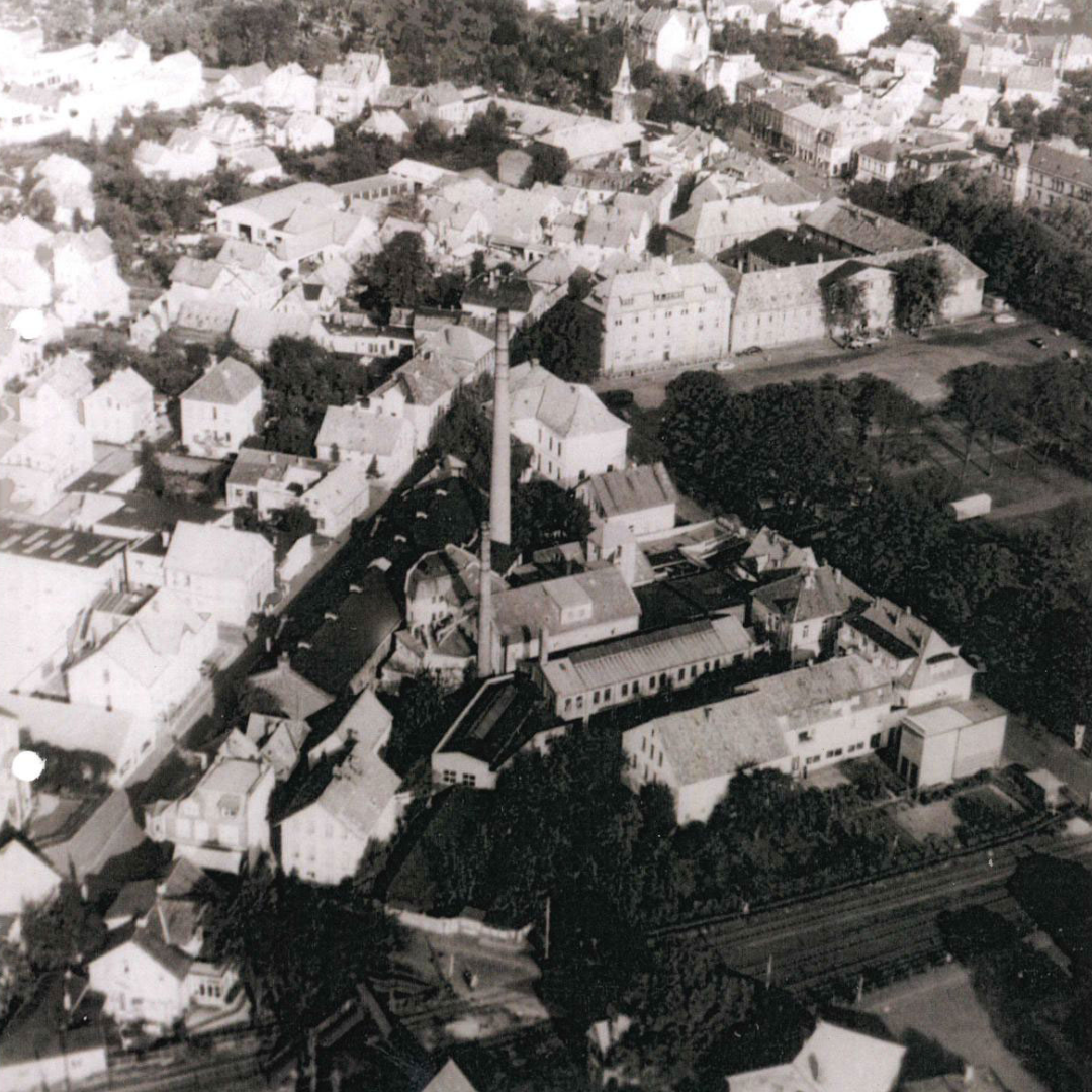 Luftaufnahme Alte Schlosserei, Pferdemarkt und Johannisviertel. um 1957, © Stadtmuseum Oldenburg/Urheber unbekannt Viele Gebäude von oben, neben Wohnhäusern auch ein Fabrikgelände mit hohem Schornstein, © Stadtmuseum Oldenburg