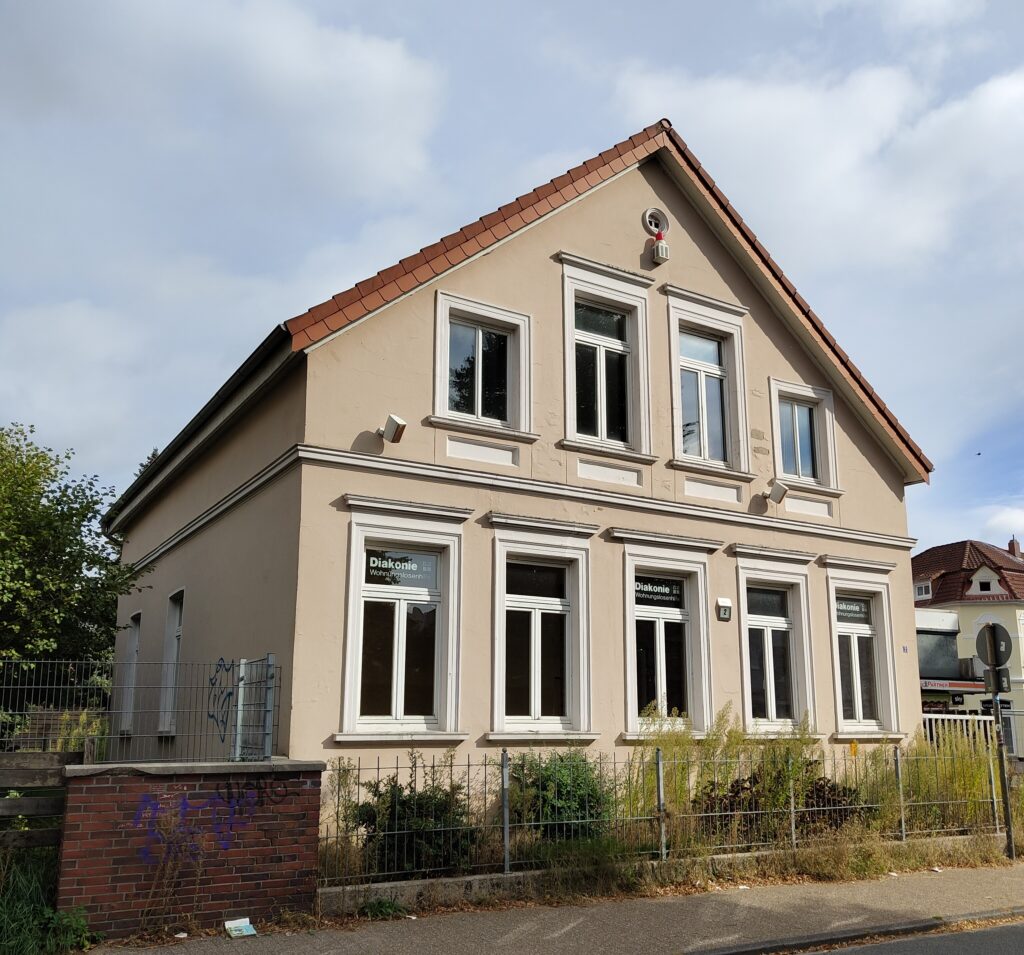 Zweistöckiges Gebäude im Stil der Oldenburger "Hundehütte", mit Metallzaun davor, © Stadtmuseum Oldenburg