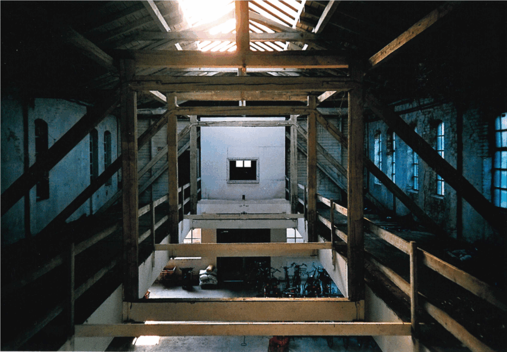 Innenansicht, Blick auf die 1942 eingebauten Sprengwerke, 17.08.1995, © Schlossmuseum Jever/Friedrich Precht Von links und rechts laufen Holzbalken zu einem Spitzdach zusammen, von oben kommt Licht durch ein Fenster, unten Blick in das darunterliegende Stockwerk, © Schlossmuseum Jever/Friedrich Precht
