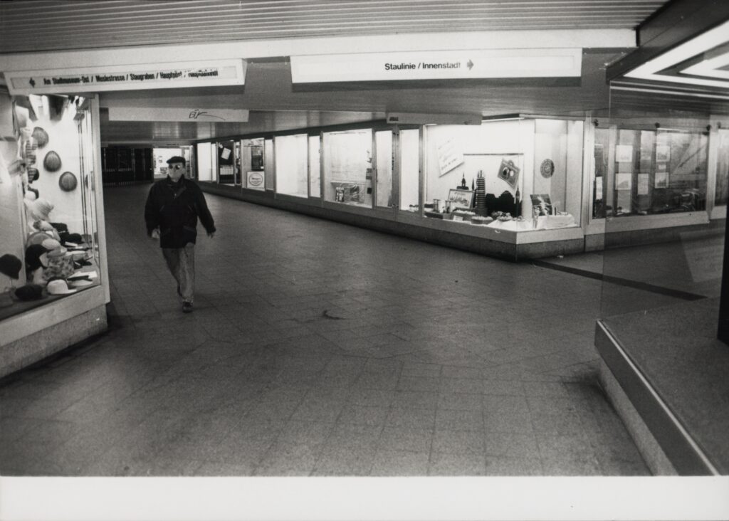Gänge im Tunnel, an den Wänden Schaufenster, an der Decke Beschilderungen, eine Person eilt vorbei, © Schlossmuseum Jever/Schmidt