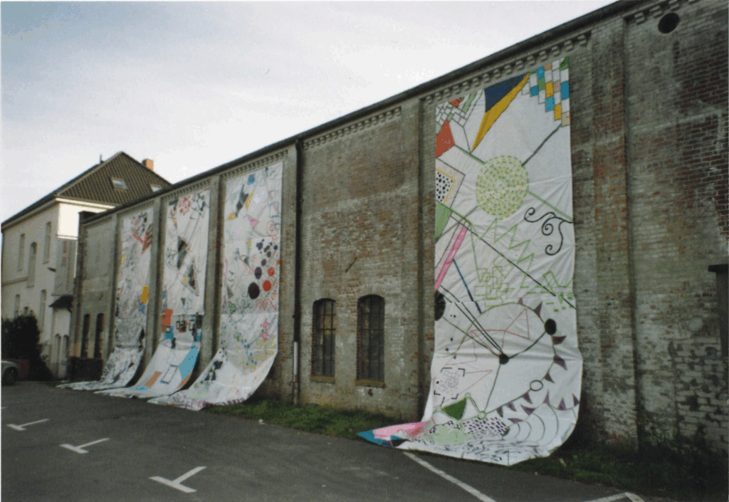 Zeichenfestival „ausgezeichnet!“ der Kunstschule Klex mit experimentellen Arbeiten von ca. 120 Schülerinnen und Schülern sowie 20 Studentinnen und Studenten. Seitenansicht der Halle mit Bannern, 14.10.2011, © Schlossmuseum Jever/Friedrich Precht Banner mit abstrakter Malerei hängen von einer ergrauten Mauer, © Schlossmuseum Jever/Friedrich Precht