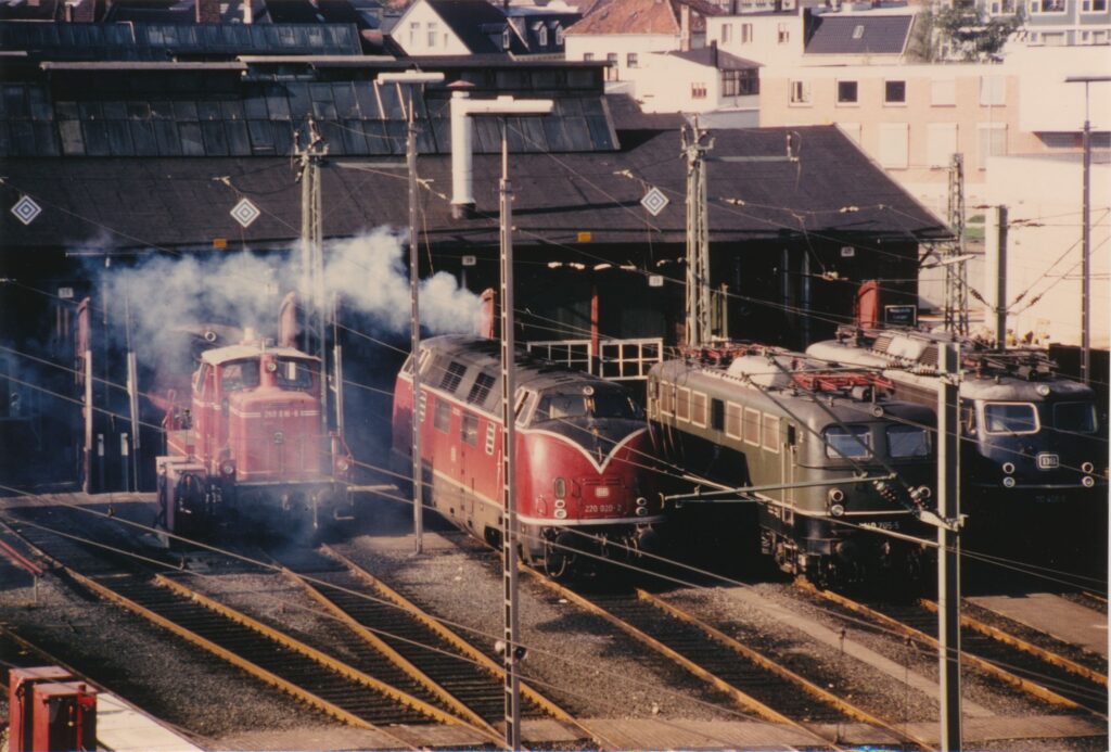 Abb. 5 Lokomotiven Vor Dem Rechtecklokschuppen. 1980. Bild Unbekannt Mehrere Lokomotiven auf Schienen vor einer Halle, © Stadtmuseum Oldenburg.