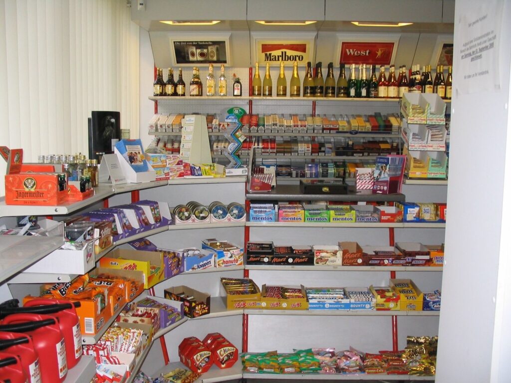 Warenauslage und Regale mit Süßigkeiten, wie Schokolade und Alkoholflaschen, wie Bier und Sekt