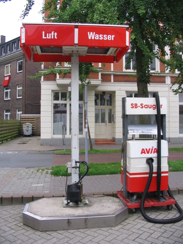 Säule, am oberen Ende auf Rotem Untergrund die Aufschrift "Luft", "Wasser", daneben ein Standgerät mit Saugschlauch