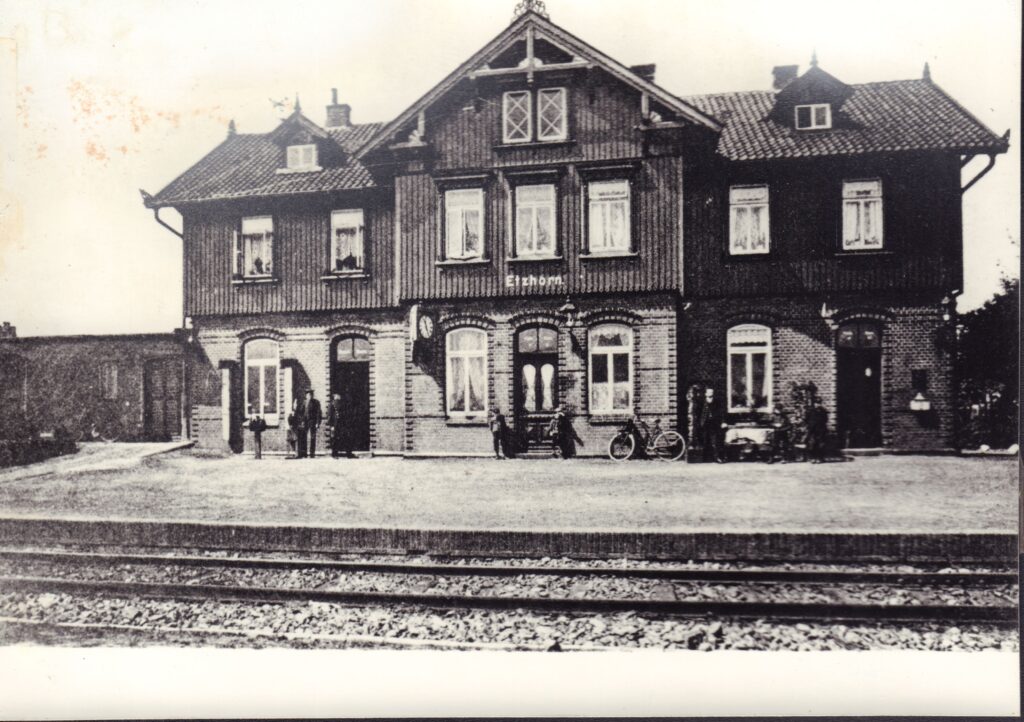 Der Etzhorner Bahnhof bot eine schnelle Verbindung nach Oldenburg. 1966, nach Einstellung des Personenverkehrs auf der Strecke, wurde das Bahnhofsgebäude abgerissen, © Stadtmuseum Oldenburg/Slg. Gaida Ein mehrstöckiges Gebäude mir Holzverkleidung und Backsteinverzierungen am unteren Stockwerk, davor ein Bahnsteig und Schienen, © Stadtmuseum Oldenburg/Slg. Gaida