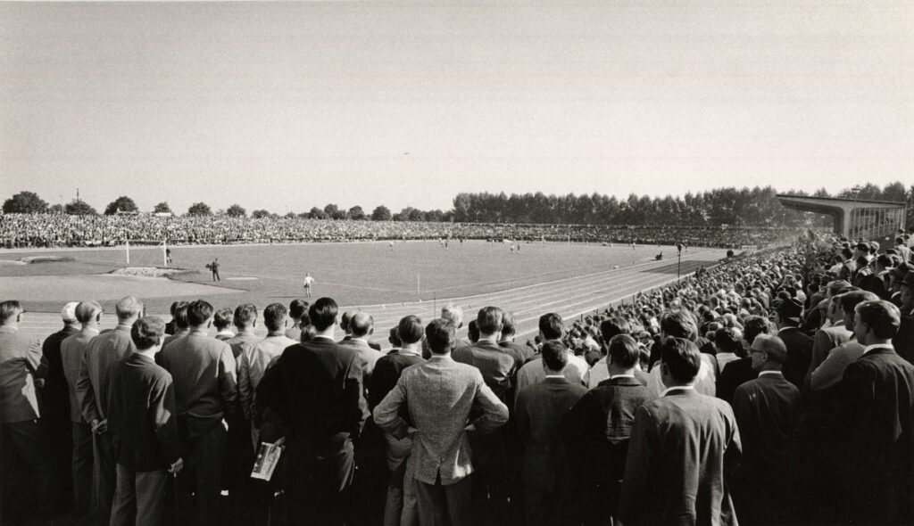 Vollbesetztes Marschwegstadion, um 1960, © Stadtmuseum Oldenburg/Günter Nordhausen Vollbesetztes Marschwegstadion um 1960 mit Zuschauern in Anzügen, die ein Fußballspiel verfolgen, © Stadtmuseum Oldenburg/Günter Nordhausen