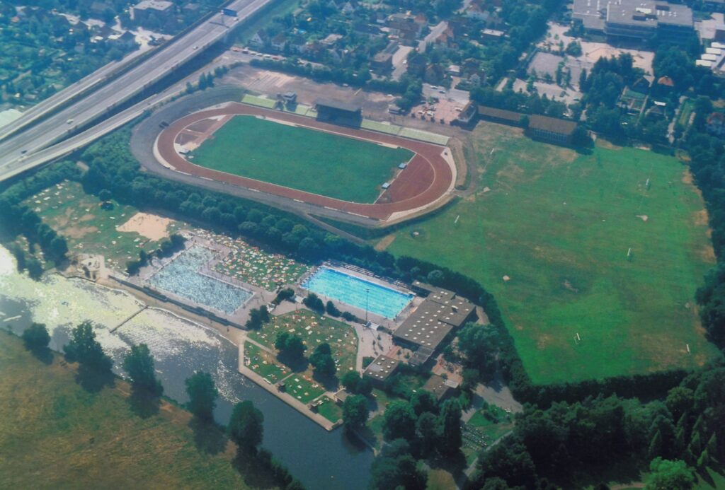 Luftaufnahme Marschwegstadion mit Huntebad, 1983, © Stadtmuseum Oldenburg/Peter Kreier Luftaufnahme von 1983 zeigt das Marschwegstadion mit Laufbahn und Spielfeld sowie das angrenzende Huntebad mit Schwimmbecken und Liegewiesen in Oldenburg, © Stadtmuseum Oldenburg/Peter Kreier