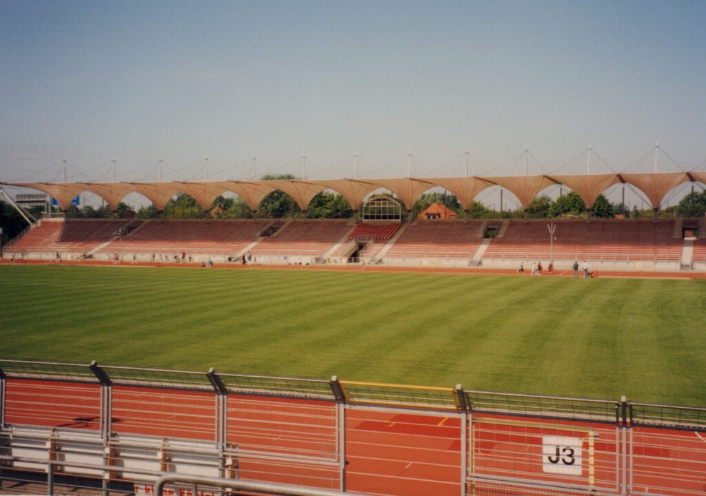 Marschwegstadion mit neuer Tribüne, Juni 1996, © Stadtmuseum Oldenburg Marschwegstadion mit neuer Tribüne aus dem Juni 1996, Blick auf die leere Sitzplatztribüne und das Spielfeld mit Laufbahn, © Stadtmuseum Oldenburg