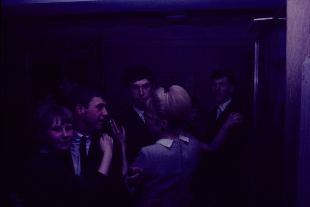 Personen in schummrigem lila Licht, unterhalten sich, © Stadtarchiv Oldenburg/Nachlass Oswald & Fritz Hancke