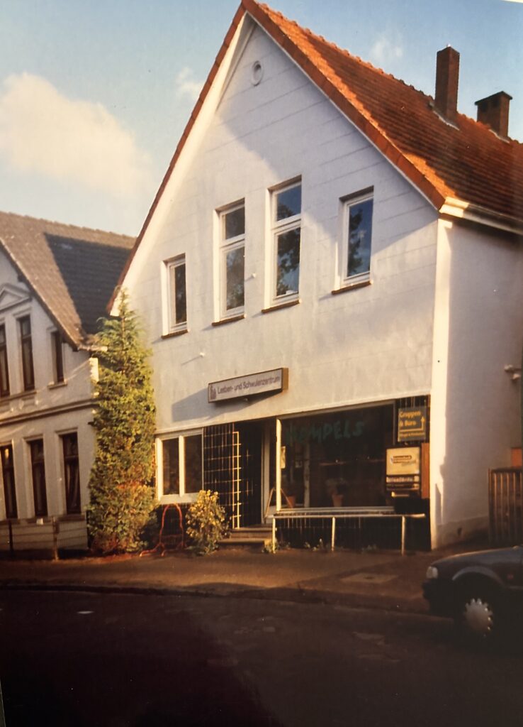 Weißes Haus mit schwarzen Kacheln am Eingang und einem Schaufenster, © Mit freundlicher Genehmigung des „Na Und e. V.“.
