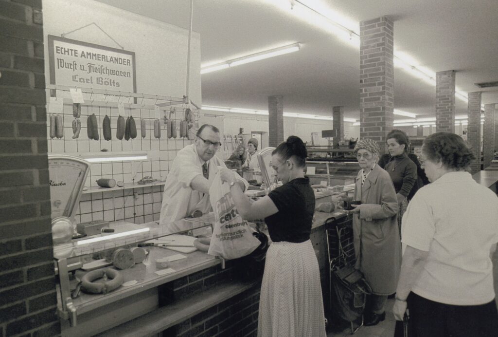 Wursttheke in einem Markt, Personen werden bedient, © Stadtmuseum Oldenburg/Peter Kreier