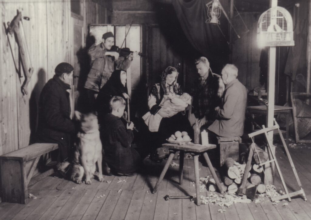 Eine Gruppe beim Krippenspiel, mit einem Hund, im Hintergrund spielt eine Person Geige, © Hermann Sokolowsky/Stadtmuseum Oldenburg