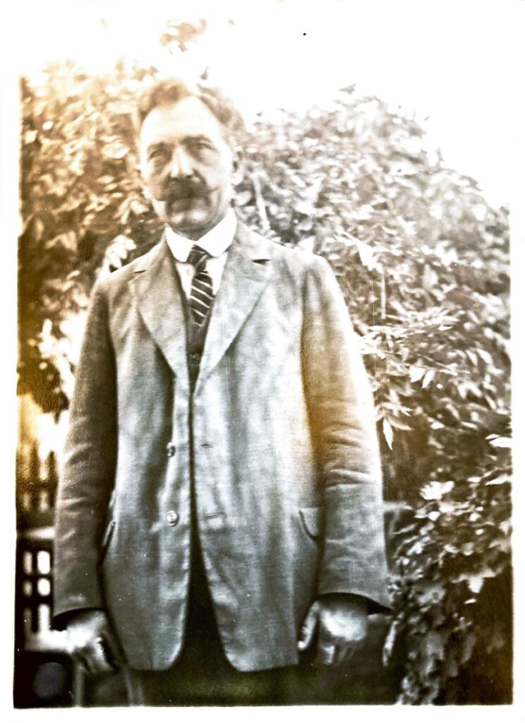 Hermann Lindemann im Garten seines Hauses an der Ziegelhofstraße um 1937, © Privatbesitz Ein Mann mit Anzug und Schnauzbart steht in einem Garten, © Privatbesitz