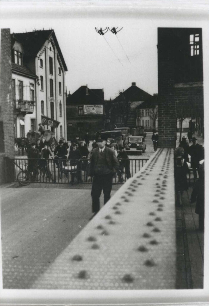 5 Wartende Passanten und Fahrradfahrer um 1936.