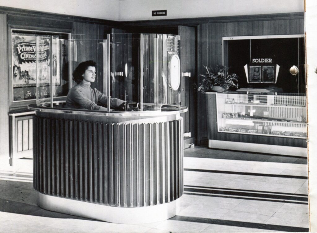 Das Kassenhäuschen mit Ticketverkäuferin im Eingangsbereich des Globe, 1950er Jahre.
