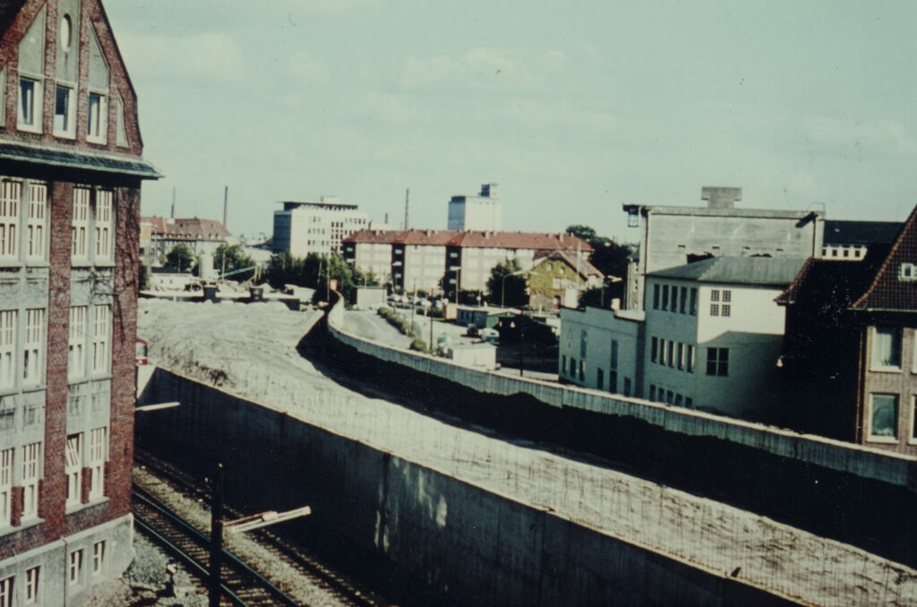 Die Stützmauern für die Bahnhochlegung im Jahr 1964. Rechts im Bild der später abgerissene Hochbunker.