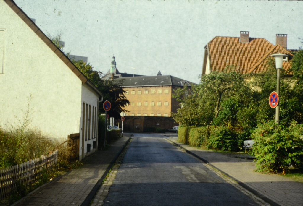 Das Bild zeigt eine Straße um 1980 im Oldenburger Gerichtsviertel und die JVA.
