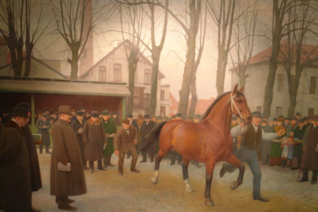 Bernhard Winter Hengstkörung Auf Dem Oldenburger Pferdemarkt Öl Auf Leinwand 1950 Stadtmuseum Oldenburg Das Ölgemälde von Bernhard Winter aus dem Jahr 1950 zeigt einen braunen Hengst, der von einem Mann an den Zügeln geführt wird. Eine große Traube Menschen hat sich auf dem Pferdemarkt versammelt.