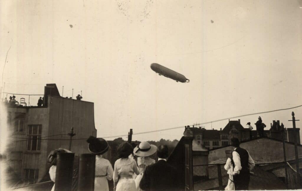 4 BA 1731 Luftschiff Victoria Luise 1912 Oldenburger:innen stehen auf den Dächern ihrer Wohnhäuser, um den Flug des Zeppelins über die Stadt zu beobachten, 1912.