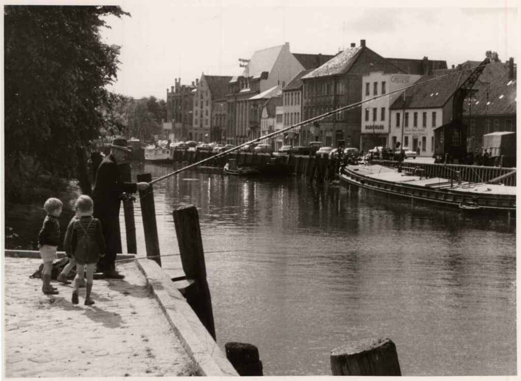 Ein Angler fischt am Stau. Das Gebäude ganz links ist der Handelshof, der 1967 abgerissen wurde. Ohne Jahr.